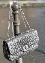 Discover The Art Of Luxury! Introducing the Desmalter Essential Bag, crafted from luxurious quilted grey leather and adorned in beautiful custom silver hardware. Emblazoned with their iconic seven pointed star, this brilliant design incorporates every element of the brand. Designed by Gedor Savenchenko with a custom turn lock and chain strap.