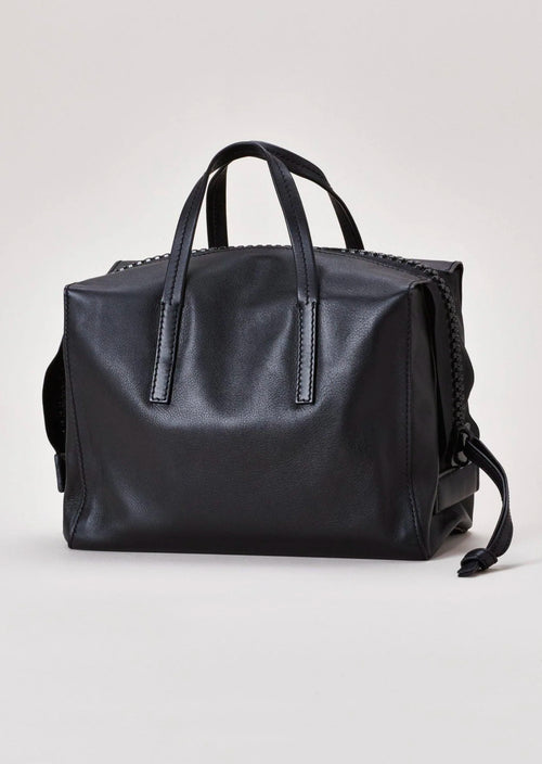 Harmin Your Handle Bag in Black. Perfectly proportioned, YOUR HANDLE is a daily companion that exudes modern glamour. Features include interior flaps for added security and can be worn handheld, on the forearm, or add adjustable strap for hands-free ease.   The adjustable strap is included in the price.  Dimensions: 12 ⅞ wide (18 ⅞” with gussets extended), 8 ¼” long, 6 ¼” deep  Made in Italy Luxury Leather Fully Washable Lining Lightweight Construction Utilitarian Zipper