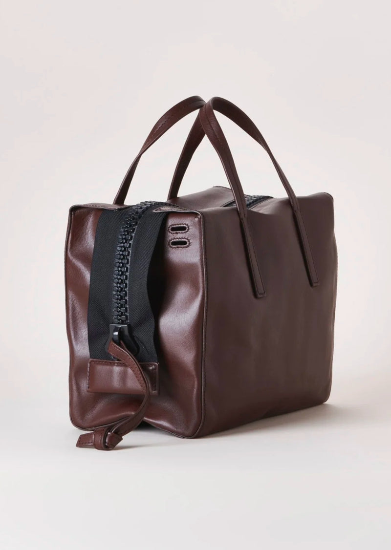 Harmin Your Handle Bag in Brown. Perfectly proportioned, YOUR HANDLE is a daily companion that exudes modern glamour. Features include interior flaps for added security and can be worn handheld, on the forearm, or add adjustable strap for hands-free ease.   The adjustable strap is included in the price.  Dimensions: 12 ⅞ wide (18 ⅞” with gussets extended), 8 ¼” long, 6 ¼” deep  Made in Italy Luxury Leather Fully Washable Lining Lightweight Construction Utilitarian Zipper