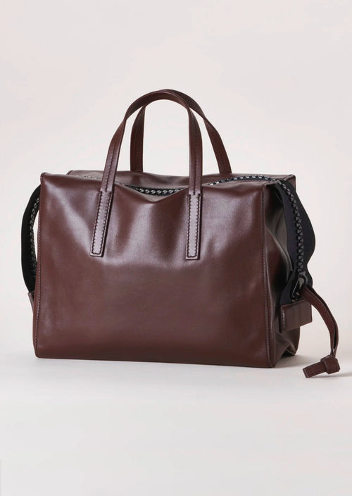 Harmin Your Handle Bag in Brown. Perfectly proportioned, YOUR HANDLE is a daily companion that exudes modern glamour. Features include interior flaps for added security and can be worn handheld, on the forearm, or add adjustable strap for hands-free ease.   The adjustable strap is included in the price.  Dimensions: 12 ⅞ wide (18 ⅞” with gussets extended), 8 ¼” long, 6 ¼” deep  Made in Italy Luxury Leather Fully Washable Lining Lightweight Construction Utilitarian Zipper