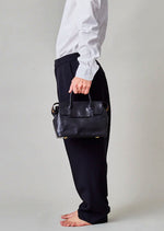 Cornelian Taurus Keyhole Mini in Black. 10" w x 7" h x 4"d Outer: 100% Cow Leather Linning: 100% Cotton Made in Japan Mini shoulder bag that can protect the contents with a flap cover. A bag with a flap cover design looks beautiful, but it takes time and effort to open the bag, which is inconvenient in terms of usability. In order to eliminate this inconvenience, a zipper is attached to the top of the bag to make opening and closing smoother and eliminate stress.
